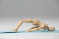 Wooden figurine exercising on exercise mat Royalty Free Stock Photo