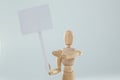Wooden figurine holding blank sign board