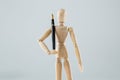 Wooden figurine holding a pen