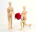 Wooden figurine man holding and giving rose Royalty Free Stock Photo