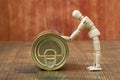 Wooden figurine of a man pushing a tin can Royalty Free Stock Photo