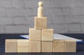 Wooden figurine of a man on top of wooden cubes. The concept of purposefulness, achieving goals