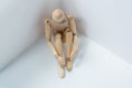 Wooden figurine sitting against wall