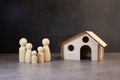 Wooden figurines of a family and a credit card near a white house