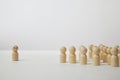 Wooden figurines with a leader and a group with partial focus. The confrontation between the head and the employees