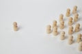 Wooden figurines with a leader and a group with partial focus. The confrontation between the head and the employees