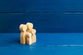 Wooden figurines of people in the shape of a family on a blue background. The concept of family values, family continuation