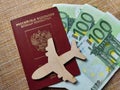 Wooden figurines, Russian citizen passport, Euro banknotes. Concept of traveling and payment. Conflict between Russia