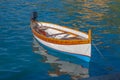 Wooden fishing boat with reflexes on the sea water