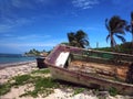 Wooden fishing boat rotting on beach with hotel in background No Royalty Free Stock Photo