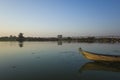 Wooden fishing boat on Taung Tha Man Lake with famous U-Bein bridge on horizon. Amarapura, Mandalay, Myanmar