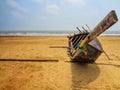 A wooden fishing boat on yellow sand at seashore of shankarpur, india