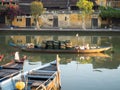 Wooden Fishing Boats in the Thu Bon River with Gold Stucco Buildings in the Background Royalty Free Stock Photo