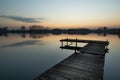 Wooden fishing platform on a calm lake and reflection of clouds in the water Royalty Free Stock Photo