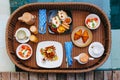 Wooden floating breakfast tray contains food and drink