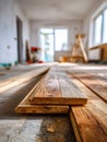 Wooden floorboards stacked inside a bright room under renovation with a stepladder and tools visible in soft focus background Royalty Free Stock Photo