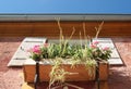 Wooden flowerbox on an old house, blue sky