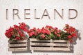 Wooden flowers boxes against an old stone wall with the word