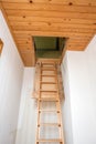 Wooden folding ladder to the attic, old empty house