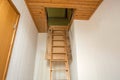 Wooden folding ladder to the attic, old empty house