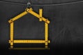 Wooden folding ruler in the shape of a house on a blackboard Royalty Free Stock Photo