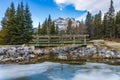 Wooden footbridge in the forest across frozen icy water surface in winter. Banff National Park, Canadian Rockies. Royalty Free Stock Photo