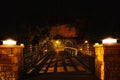 A wooden footbridge illuminated at night