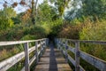 Wooden footbridge leading to a small tree tunnel Royalty Free Stock Photo