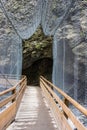 A wooden footbridge over a mountain river. A steel mesh protects the passage Royalty Free Stock Photo