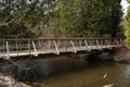 Wooden footbridge in the park crossing the river on a spring day Royalty Free Stock Photo