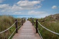 Wooden footbridge between sand dunes to the beach and ocean at menorca spain Royalty Free Stock Photo