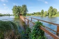 Wooden footbridge to island with hut and trees on lake Royalty Free Stock Photo