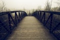 Wooden footpath bridge with mist and fog in a wood in winter. Canada