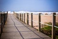 Wooden footpath through dunes at the ocean beach Royalty Free Stock Photo