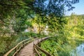 Wooden footpath at Plitvice national park, Croatia. Pathway in the forest near the lake and waterfall. Fresh beautiful nature, Royalty Free Stock Photo