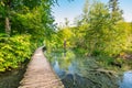 Wooden footpath at Plitvice national park, Croatia. Pathway in the forest near the lake and waterfall. Fresh beautiful nature, Royalty Free Stock Photo