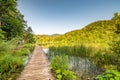 Wooden footpath at Plitvice national park, Croatia. Pathway in the forest near the lake and waterfall. Fresh beautiful nature, Royalty Free Stock Photo