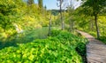 Wooden footpath at Plitvice national park, Croatia. Pathway in the forest near the lake and waterfall. Fresh beautiful nature, Royalty Free Stock Photo