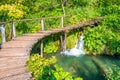 Wooden footpath at Plitvice national park, Croatia. Pathway in the forest near the lake and waterfall. Fresh beautiful nature, Royalty Free Stock Photo