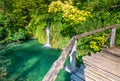 Wooden footpath at Plitvice national park, Croatia. Pathway in the forest near the lake and waterfall. Fresh beautiful nature, Royalty Free Stock Photo