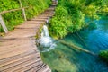 Wooden footpath at Plitvice national park, Croatia. Pathway in the forest near the lake and waterfall. Fresh beautiful nature, Royalty Free Stock Photo