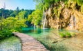 Wooden footpath at Plitvice national park, Croatia. Pathway in the forest near the lake and waterfall. Fresh beautiful nature, Royalty Free Stock Photo