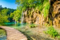 Wooden footpath at Plitvice national park, Croatia. Pathway in the forest near the lake and waterfall. Fresh beautiful nature, Royalty Free Stock Photo