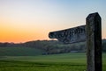 A wooden footpath sign in the english countryside at sunset with rolling green hills in the background Royalty Free Stock Photo