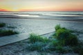 Wooden footpath to the sea at sunset. Royalty Free Stock Photo