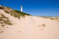 wooden footway on sand next to the lighthouse of Trafalgar horizontal