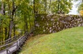 Wooden forest path and the fragment of stone wall of the Sigulda Medieval Castle, Latvia Royalty Free Stock Photo