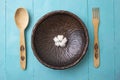 Wooden fork, spoon and sculpted bowl with a cotton flower