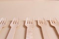 Wooden forks lie in a row on a cream background. Rhythm. Royalty Free Stock Photo