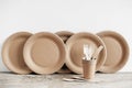 Wooden forks and paper cups with plates on wooden background. Eco friendly disposable tableware. Also used in fast food,